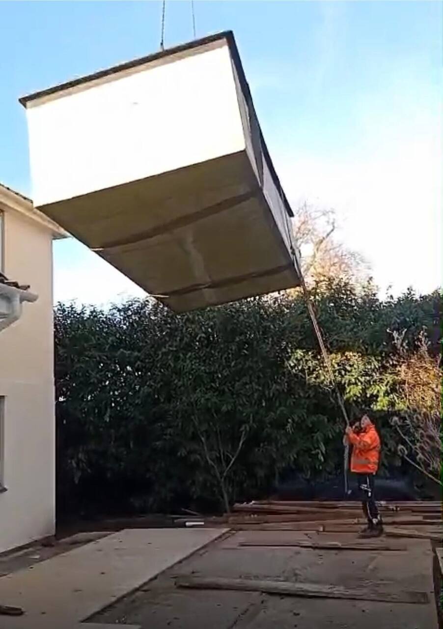 Crane lifting a prefabricated panel into place on site