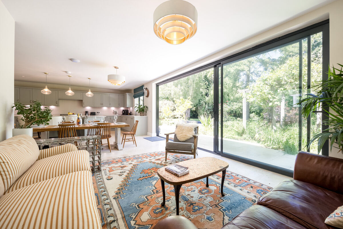 Open-plan living space with full-width sliding glass doors onto the garden, built by Cape Build